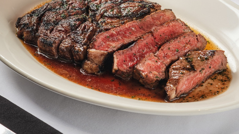 Morton's The Steakhouse Dry-Aged Ribeye sliced and juicy on a plate.