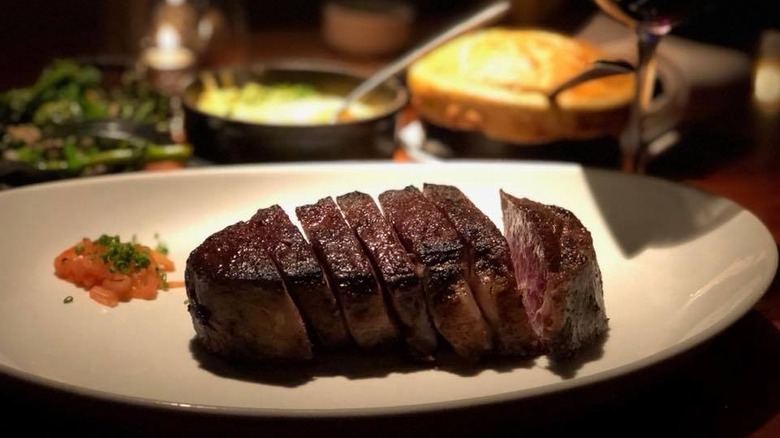 STK Dry Aged Delmonico sliced up on a plate.