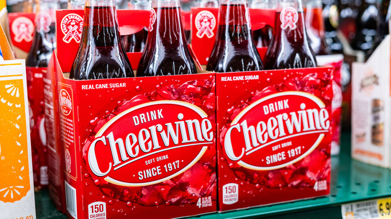 Four backs of Cheerwine in glass bottles, showing bright red packaging