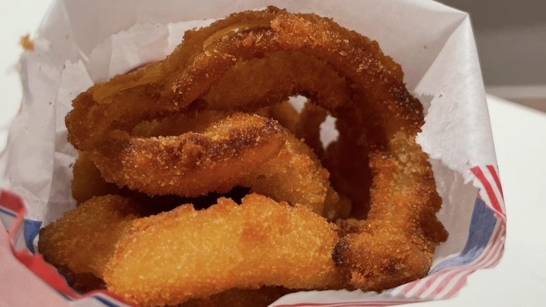 Person holding up a bag of Sonic onion rings