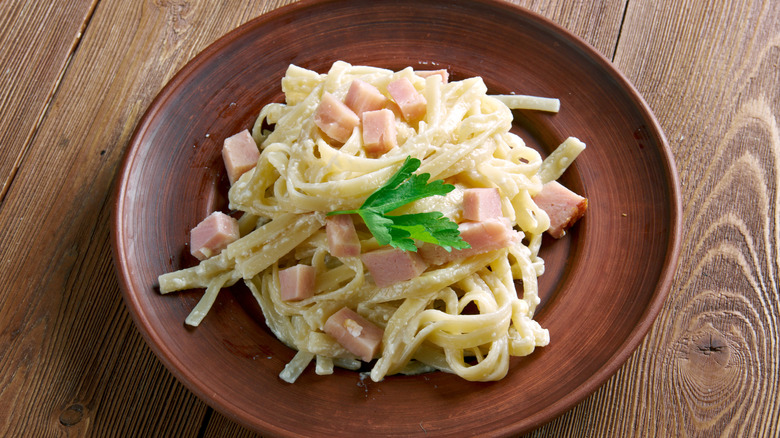 Fettuccine with ham and cheese and topped with parsely