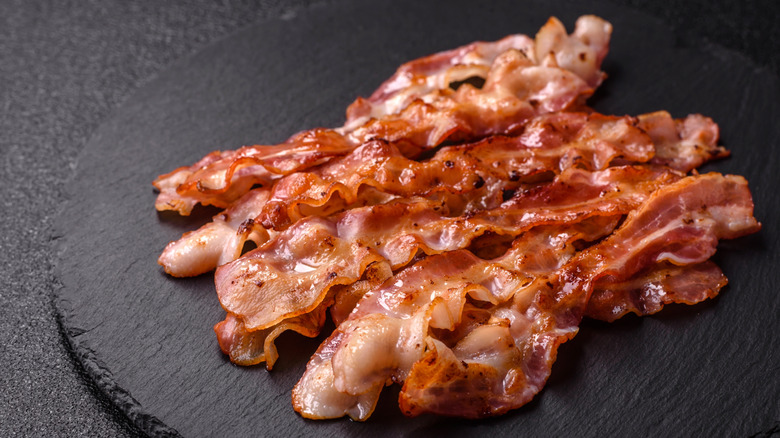 cooked bacon on a black background
