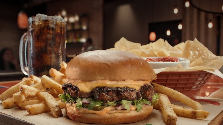Chili's Big Smasher Burger with fries and chips and salsa in the background.