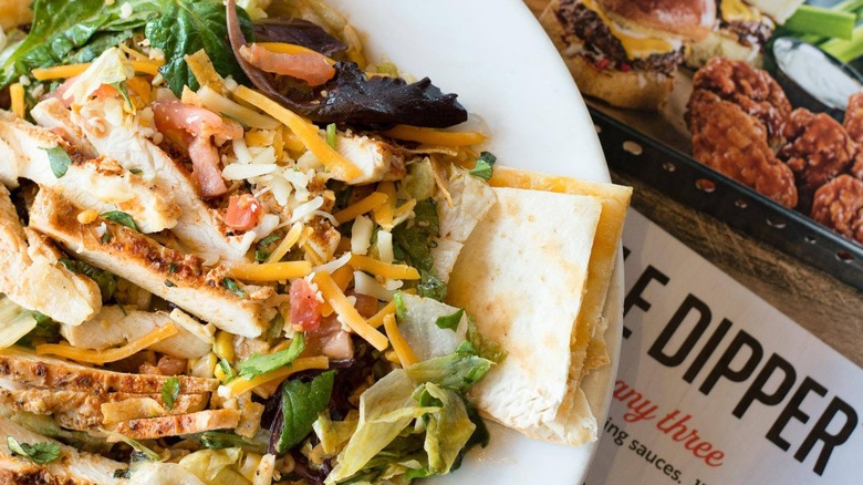 Chili's Quesadilla Explosion Salad next to a menu.