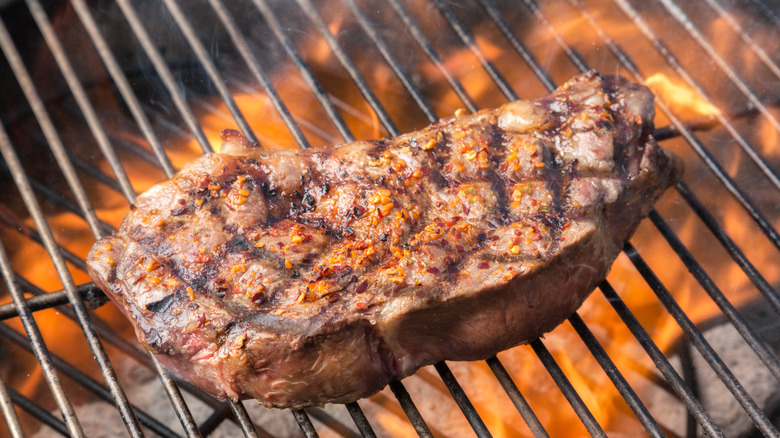 New York steak cooking on a grill