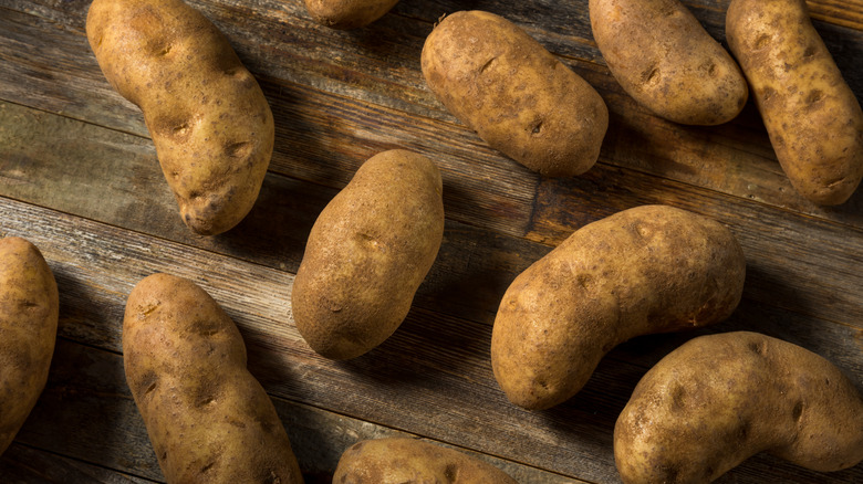 Russet potatoes on wooden surface