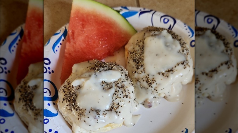 Biscuits and gravy served with a slice of watermelon