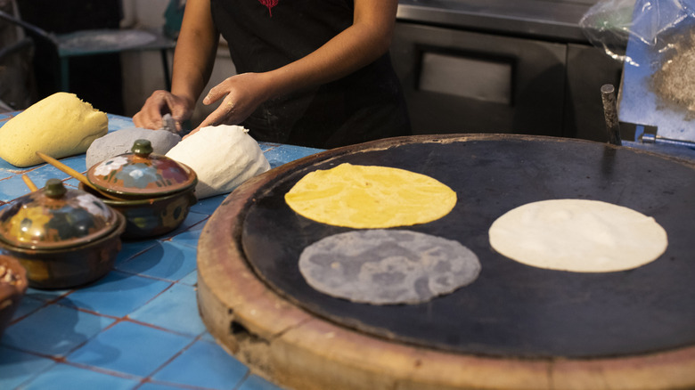 three types of corn tortillas cooking on comel