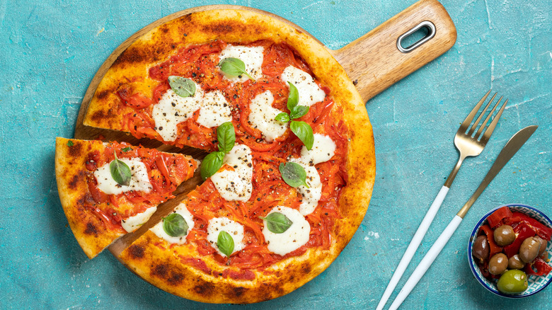 Margherita pizza on wooden serving board.