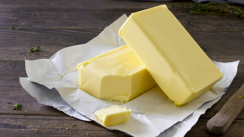 Butter served on wooden cutting board.