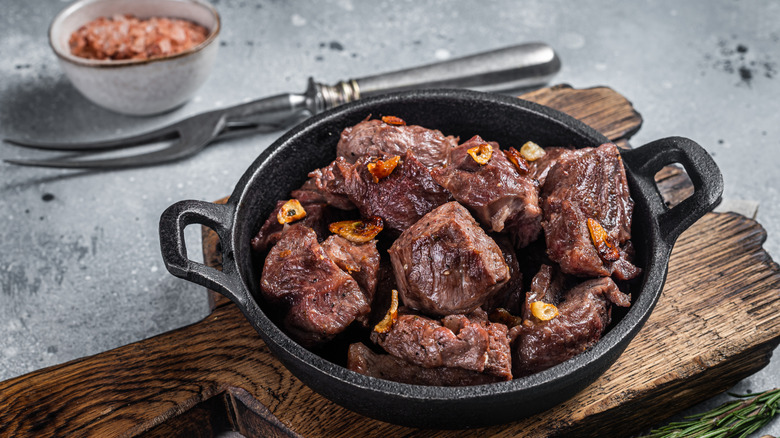 beef tips in a mini cast iron with fried garlic