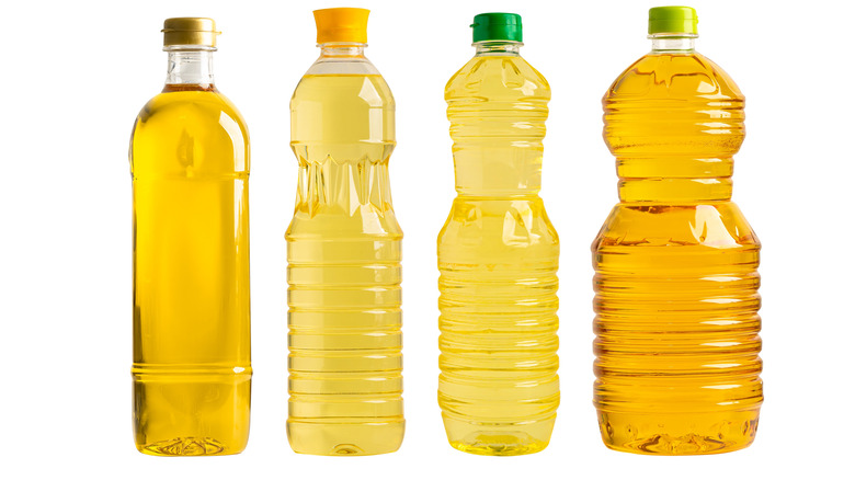 A selection of unlabeled cooking oils against a white background