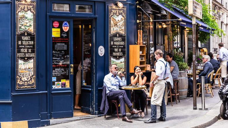 Diners sit outside at a French restaurant for lunch