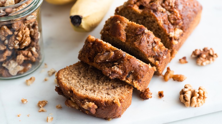Homemade banana bread with walnuts cut into slices, closeup view