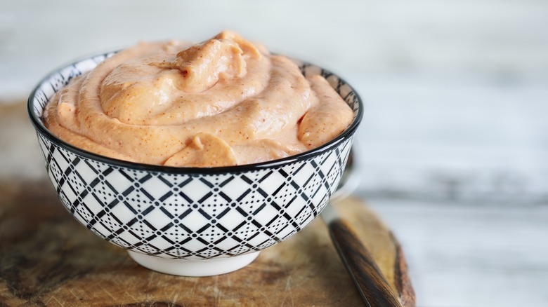Dipping bowl full of a creamy orange mayo-based sauce