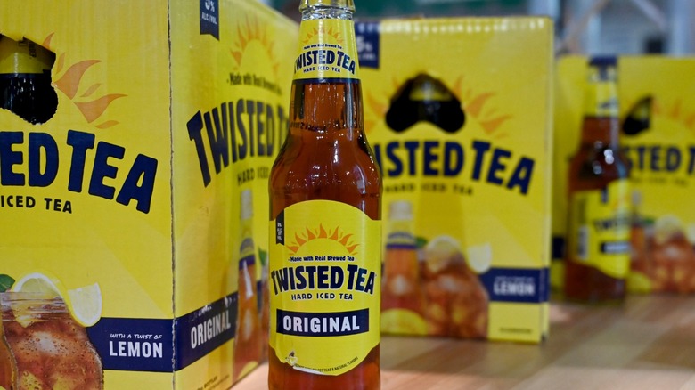 A bottle of Twisted Tea surrounded by boxes of Twisted Tea