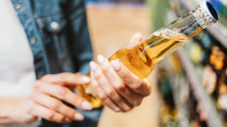 Woman holding alcohol bottle