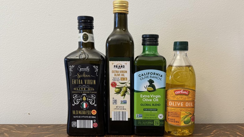 Four olive oils sold at Aldi on a table.