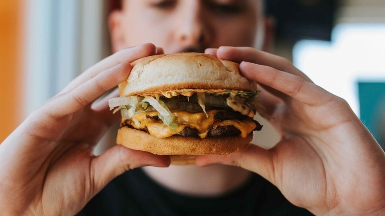 A diner holds a double spicy Papa burger from an A&W restaurant