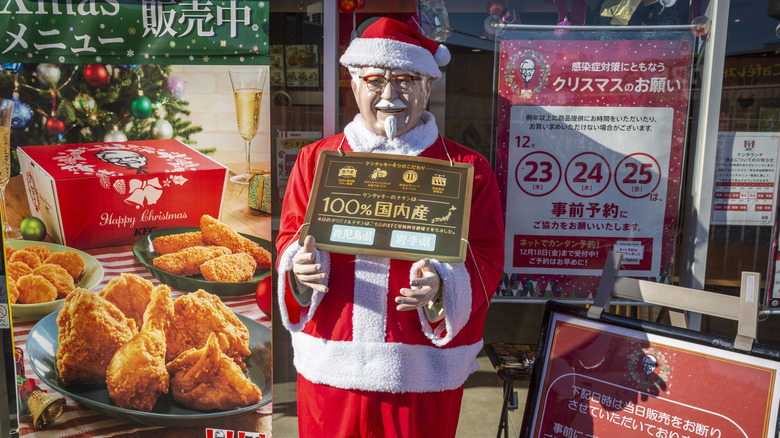 A statue of Colonel Sanders dressed as Santa outside a Japanese KFC location