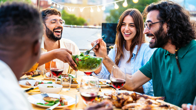 People passing plates at outdoor dinner party