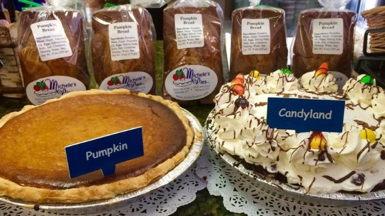 Michele's Pies' Pumpkin Pie and cream-topped Candyland Pie in front of bags of Pumpkin Bread