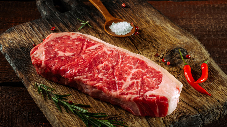 Raw steak with salt and other seasonings