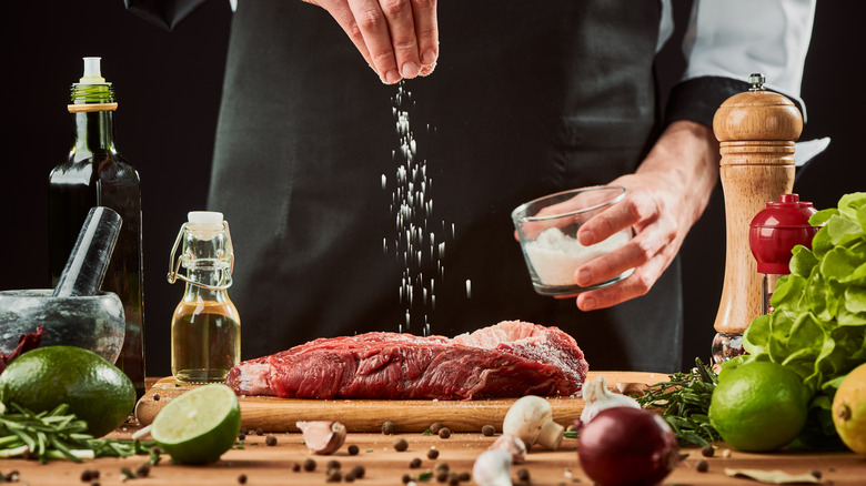Sprinkling salt on raw steak