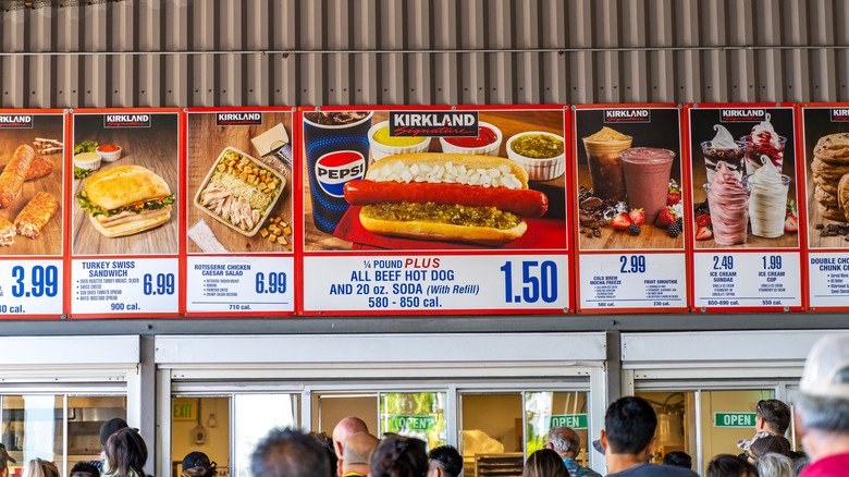 People standing in line at a Costco food court.