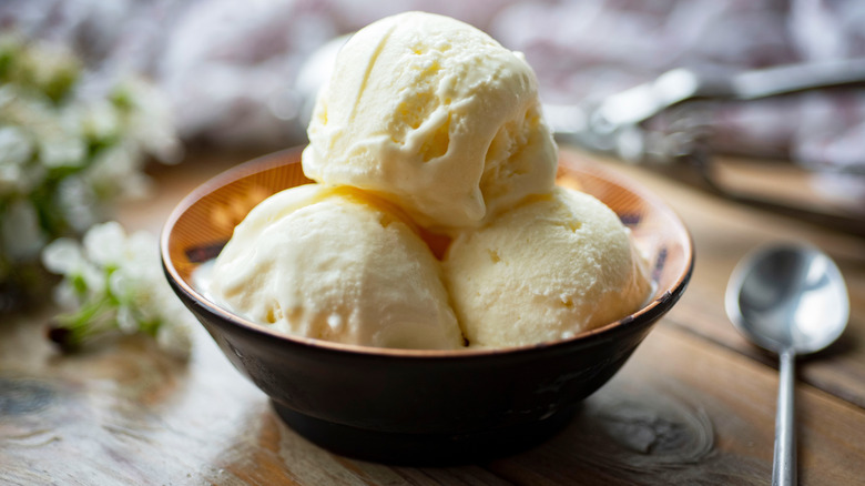 Three scoops of vanilla ice cream in a bowl on a table