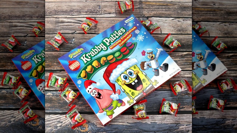 A SpongeBob SquarePants Krabby Patties advent calendar is surrounded by Krabby Patty candies