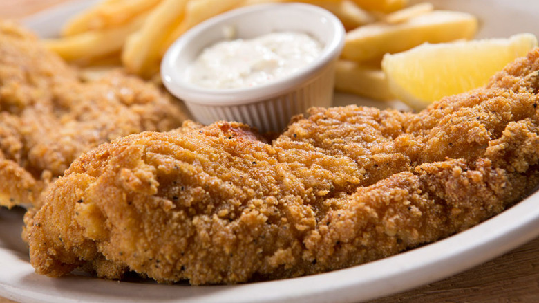 Fried catfish fillets with fries, tartar sauce, and lemon from Logan's Roadhouse.