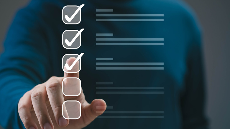 A human hand ticking off a digital checklist