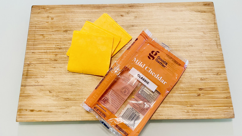 Package of Good & Gather Mild Cheddar Cheese with half of a grilled cheese sandwich