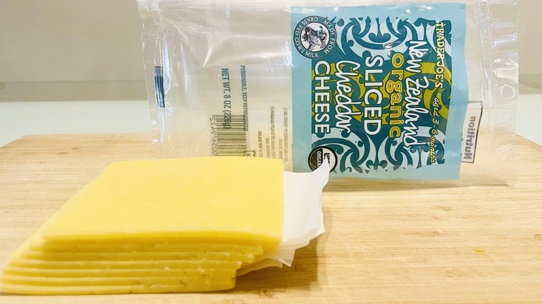 Stack of sliced Trader Joe's New Zealand Organic Cheddar Cheese with packaging