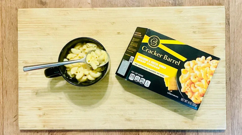 Cracker Barrel mac and cheese in a bowl next to the packaging.