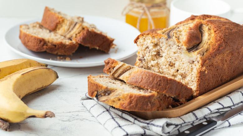 Banana bread next to fresh bananas