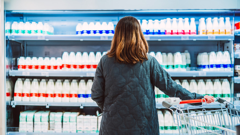 A person shopping for milk in a supermarket