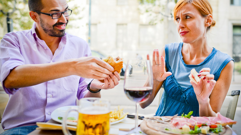 Woman refusing food offering from man