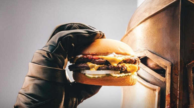 Closeup on a knight in armor holding up a Carl's Jr. Angus Maximus