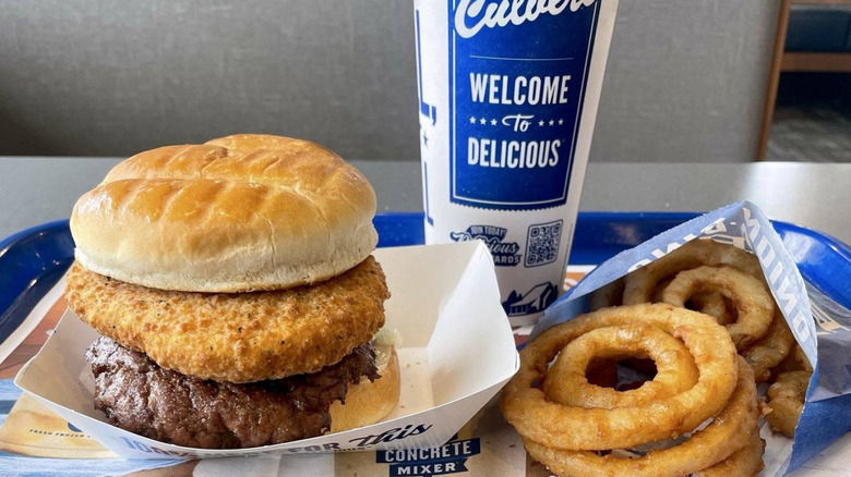 A Culver's Smoked Cheddar CurderBurger with a soda and onion rings.