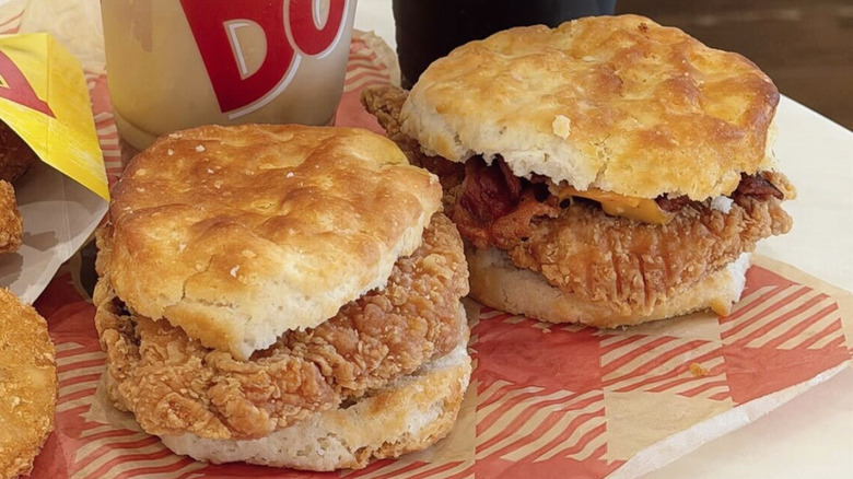 Two biscuit sandwiches from Bojangles sit on wrapping paper