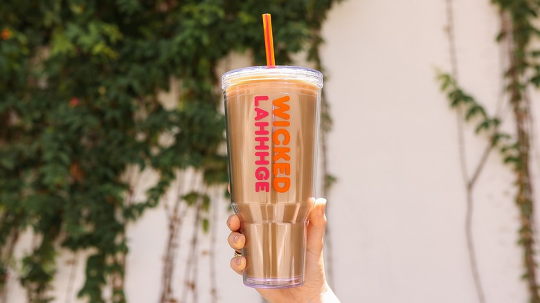 Person holding a coffee tumbler