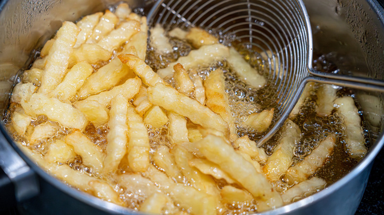 Fries being removed from bubbling oil