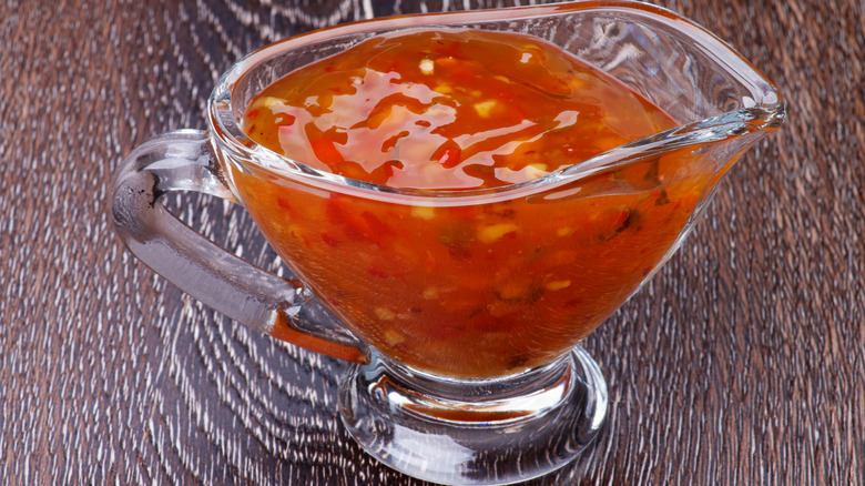 Serving vessel filled with sweet 'n sour sauce.