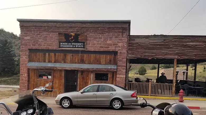 A redbrick building with an outside seating area to the left