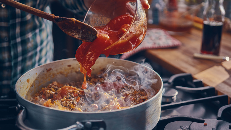 person making meat sauce