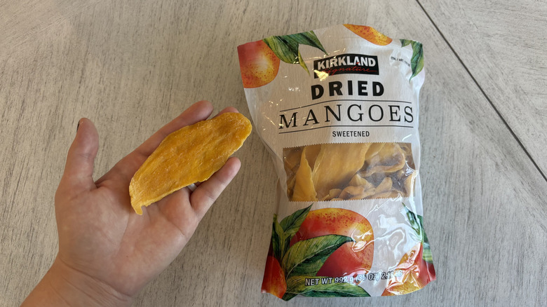Person holding a Kirkland Signature dried mango