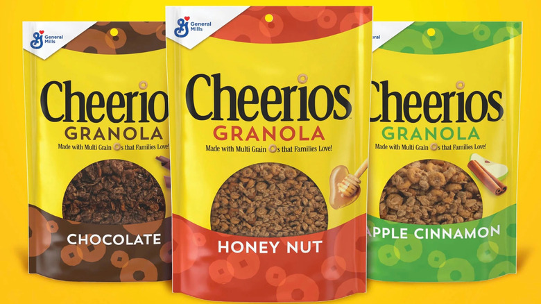 Bags of Chocolate, Honey Nut, and Apple Cinnamon Cheerios Granola against a yellow background