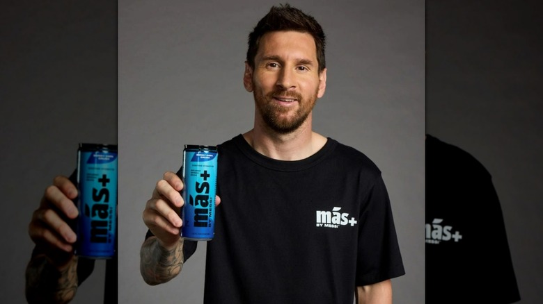 Soccer star Lionel Messi holds up a can of Berry Copa Crush-flavored Mas+ by Messi.